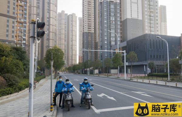 资料图片：1月31日，在武汉市汉阳区，外卖小哥在空旷的马路上合影留念。（新华社）